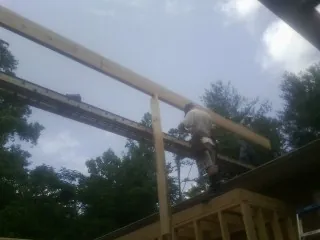 Carpenter setting a ridge beam over a new addition frame — Ice Dam Removal by Roofing Brothers in Pacific Beach