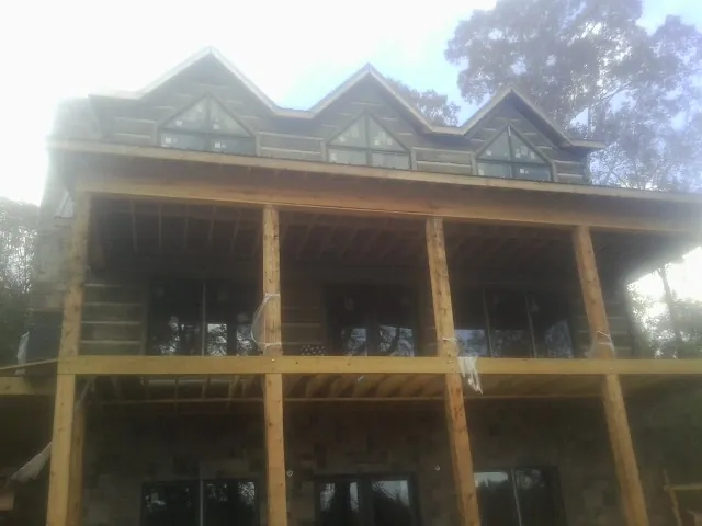 Dormers and porch framing on a large log home under construction — Roof Coating work by our crew in Pacific Beach